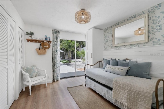 bedroom featuring access to exterior, hardwood / wood-style flooring, and a closet