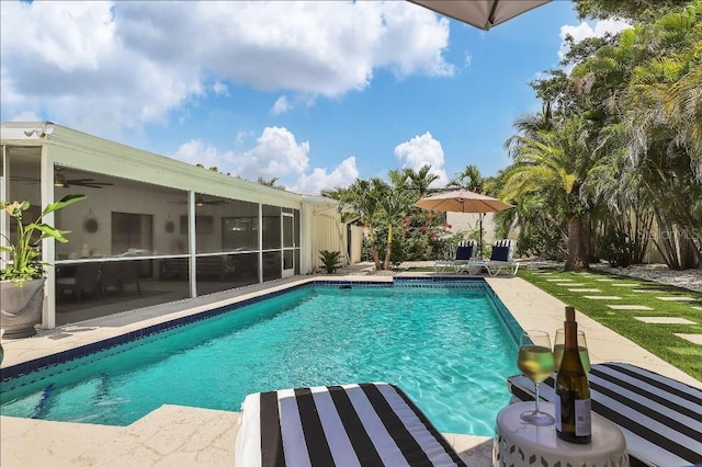 view of swimming pool with a patio area, ceiling fan, and a sunroom