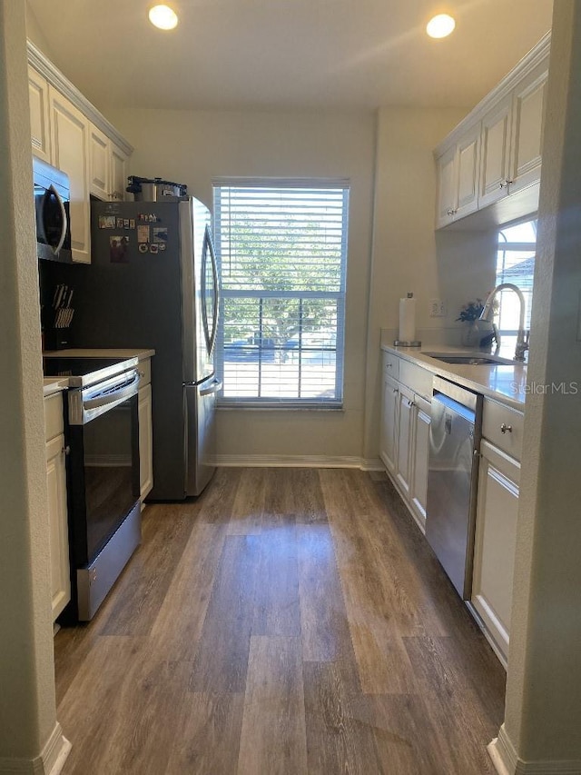 kitchen featuring white cabinets, appliances with stainless steel finishes, dark wood-type flooring, and sink