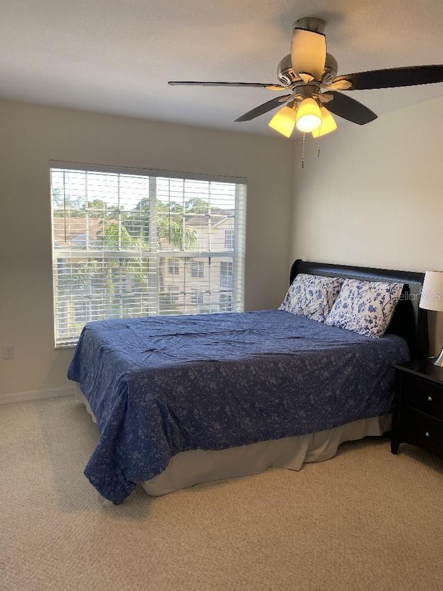 carpeted bedroom featuring multiple windows and ceiling fan