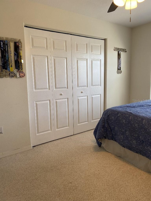 bedroom featuring carpet flooring, ceiling fan, and a closet