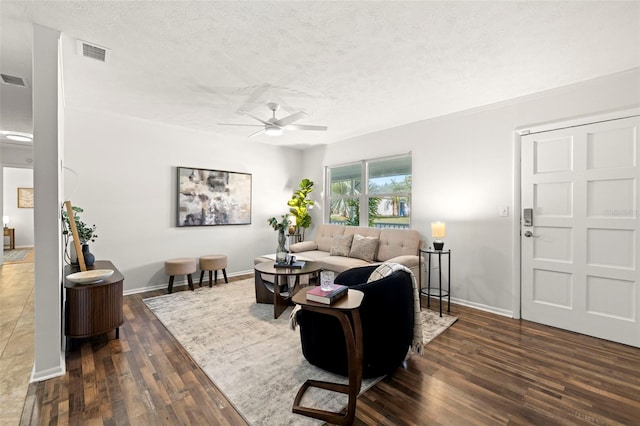 living room featuring a textured ceiling, dark wood-type flooring, and ceiling fan