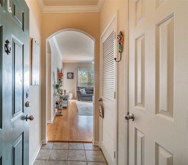 hall with crown molding and light tile patterned flooring