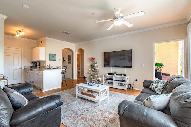 living room with ceiling fan, light hardwood / wood-style flooring, and ornamental molding