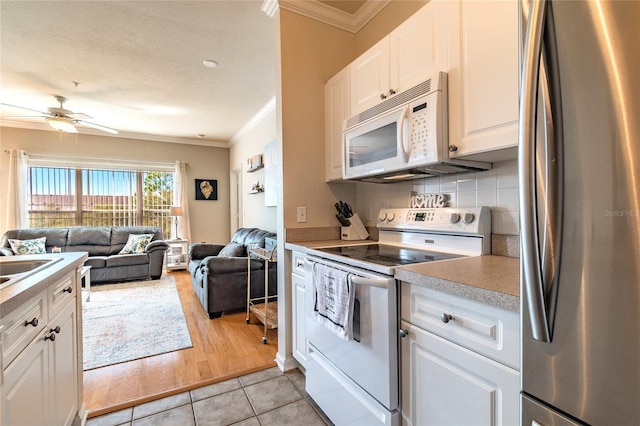 kitchen featuring backsplash, white appliances, ceiling fan, white cabinets, and light tile patterned flooring