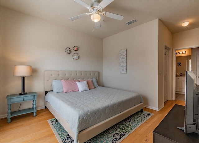 bedroom with connected bathroom, light hardwood / wood-style floors, and ceiling fan