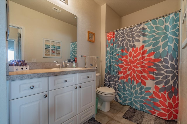 bathroom featuring tile patterned flooring, vanity, and toilet