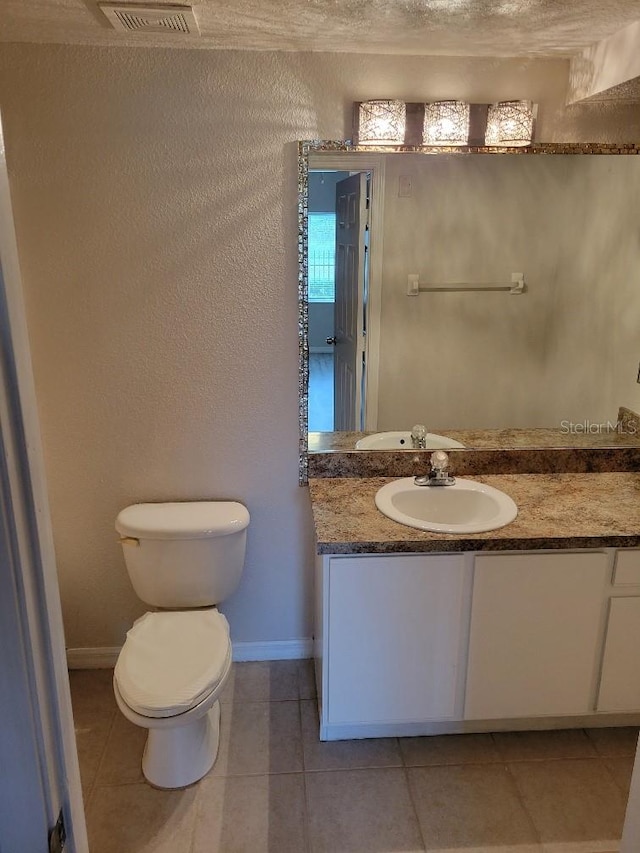 bathroom with tile patterned floors, vanity, and toilet