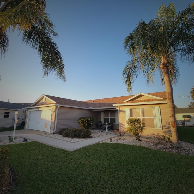 ranch-style home with a garage and a front lawn