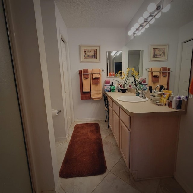 bathroom featuring tile patterned floors, vanity, and a textured ceiling