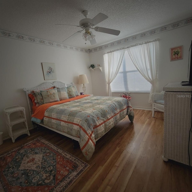 bedroom with hardwood / wood-style floors, a textured ceiling, and ceiling fan