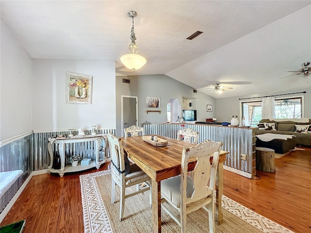 dining area featuring hardwood / wood-style floors, a textured ceiling, ceiling fan, and lofted ceiling