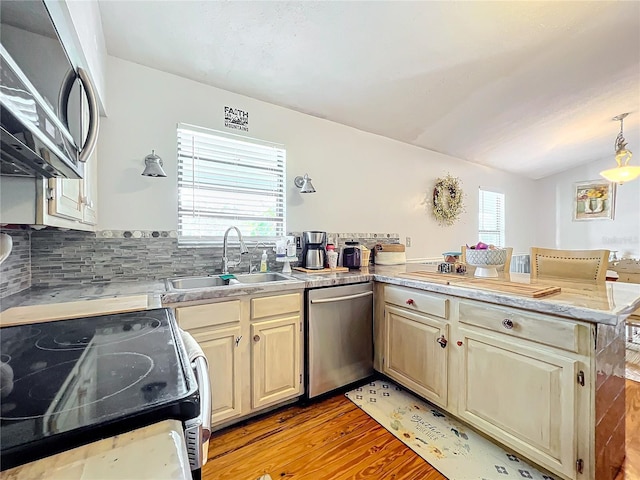 kitchen featuring kitchen peninsula, stainless steel dishwasher, sink, range, and light hardwood / wood-style floors