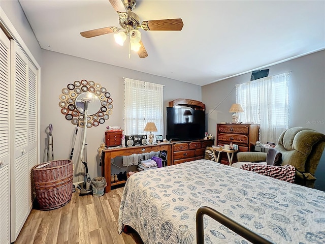 bedroom with light hardwood / wood-style flooring, a closet, and ceiling fan