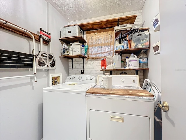 laundry room with independent washer and dryer and a textured ceiling