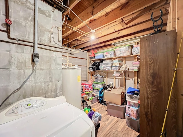 laundry area with washer / clothes dryer, water heater, and light wood-type flooring