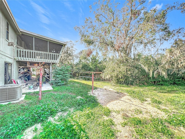 view of yard with central AC unit and a sunroom