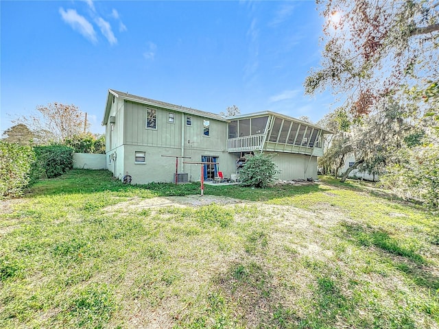 back of property with a sunroom, a yard, and cooling unit