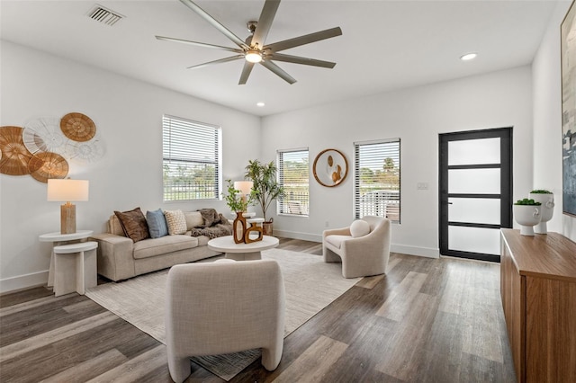 living room featuring ceiling fan and dark hardwood / wood-style floors