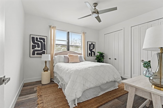 bedroom featuring ceiling fan, dark hardwood / wood-style floors, and multiple closets