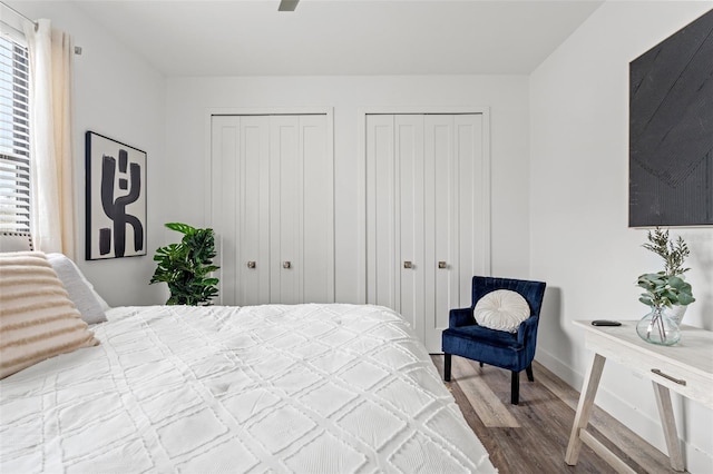 bedroom with hardwood / wood-style flooring and multiple closets