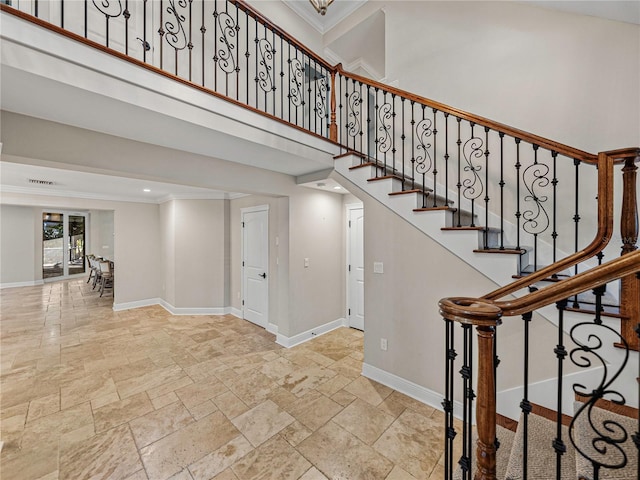 stairway with a high ceiling and ornamental molding