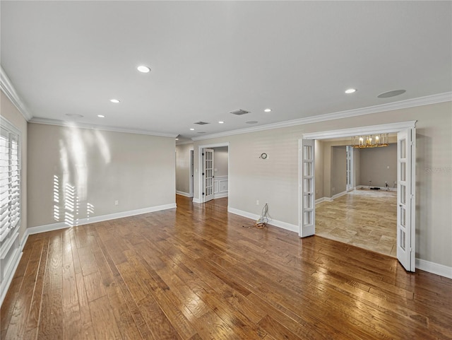 unfurnished living room featuring french doors, crown molding, and hardwood / wood-style floors