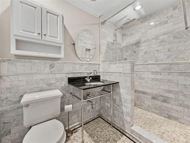 bathroom with tiled shower, tile walls, crown molding, and sink