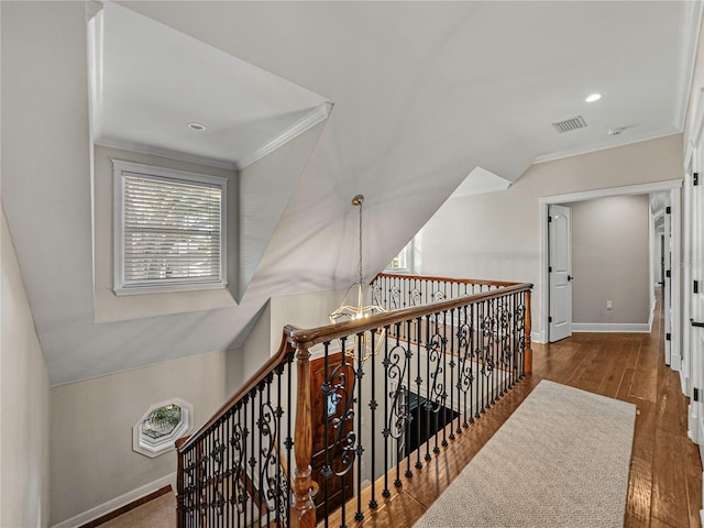 hallway featuring vaulted ceiling, a notable chandelier, dark hardwood / wood-style floors, and ornamental molding