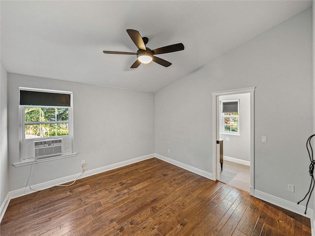 spare room with dark wood-type flooring, plenty of natural light, and lofted ceiling