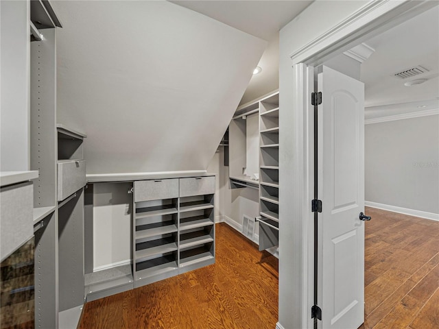 spacious closet with hardwood / wood-style flooring and vaulted ceiling