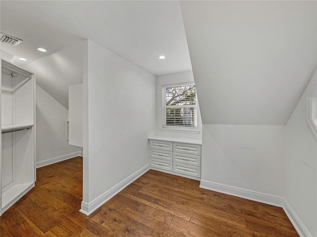 additional living space featuring dark wood-type flooring and lofted ceiling