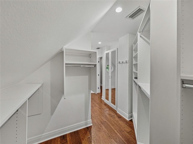 spacious closet featuring wood-type flooring and lofted ceiling