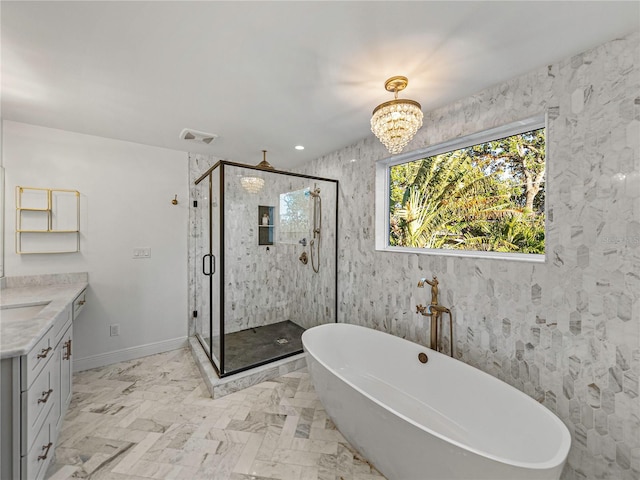 bathroom with a notable chandelier, vanity, and independent shower and bath