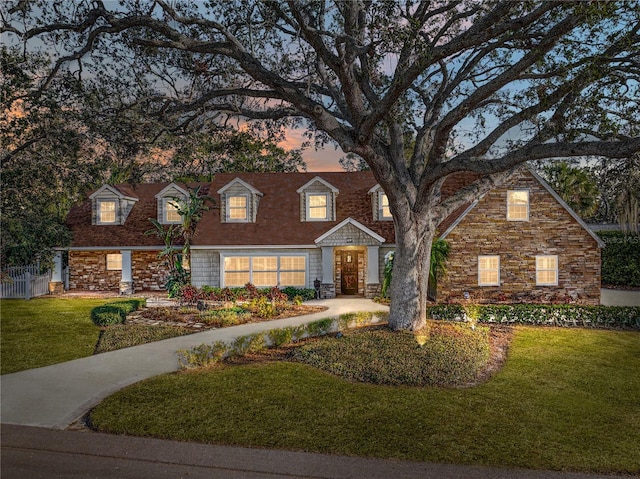 view of front facade featuring a front yard and stone siding