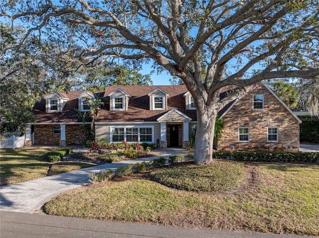 view of front of home featuring stone siding and a front yard