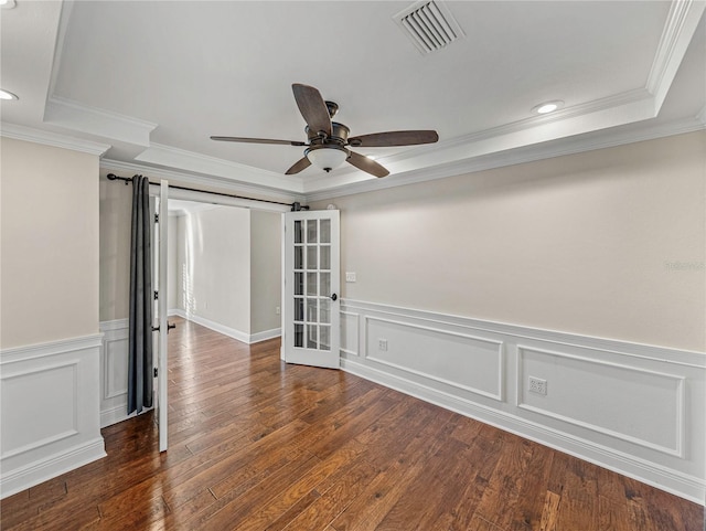 empty room featuring a tray ceiling, crown molding, french doors, and ceiling fan