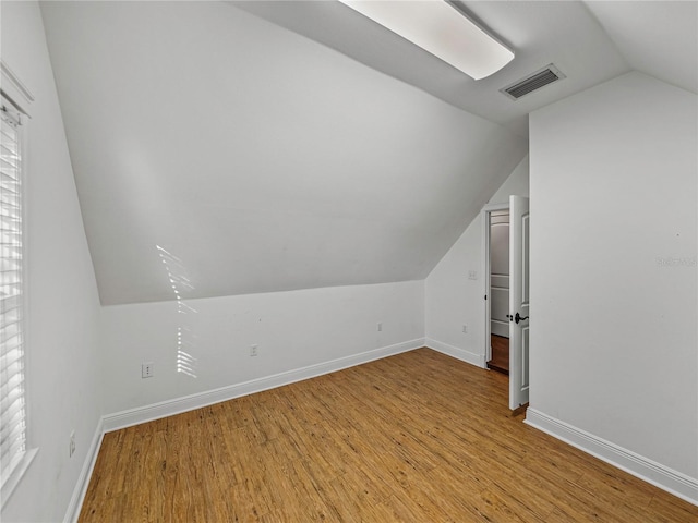 bonus room with lofted ceiling and light hardwood / wood-style flooring