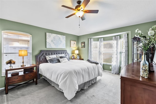 carpeted bedroom featuring multiple windows and ceiling fan