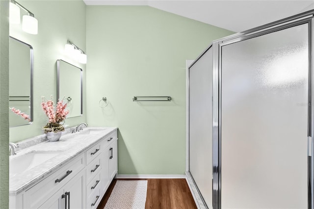 bathroom featuring hardwood / wood-style floors, vanity, a shower with shower door, and vaulted ceiling