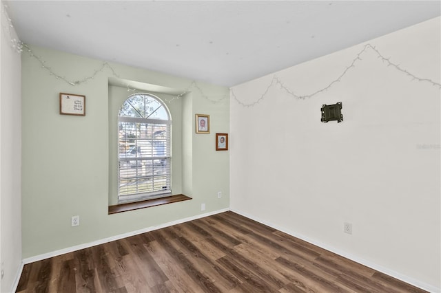 unfurnished room with dark wood-type flooring