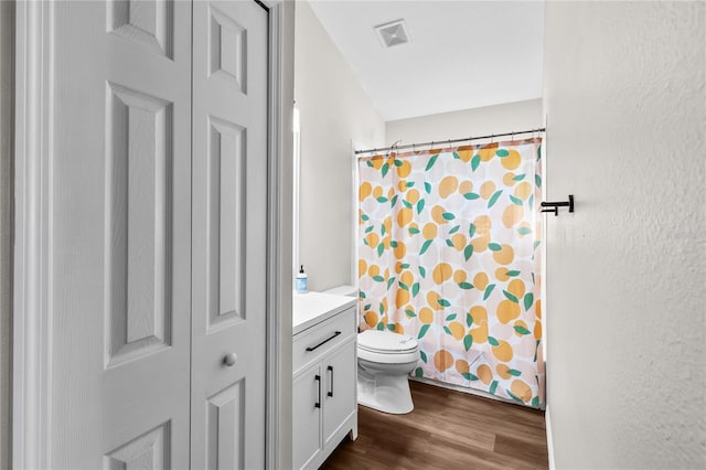 bathroom with hardwood / wood-style floors, vanity, toilet, and a shower with curtain