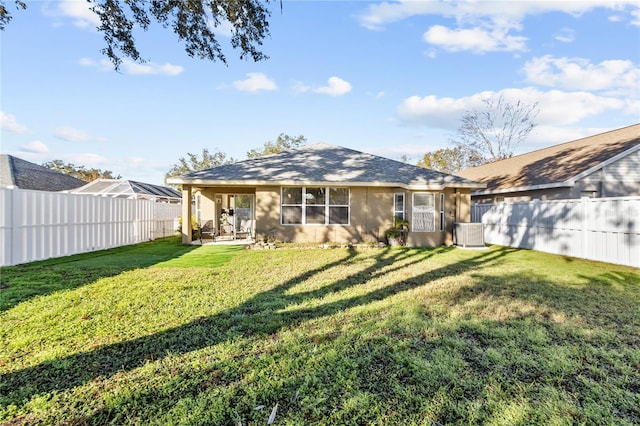 rear view of house featuring a lawn, a patio area, and central AC unit