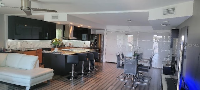 kitchen featuring backsplash, sink, a kitchen island, stainless steel fridge with ice dispenser, and extractor fan