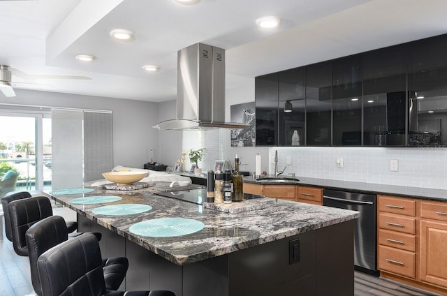 kitchen with ceiling fan, dishwasher, sink, dark stone counters, and island range hood