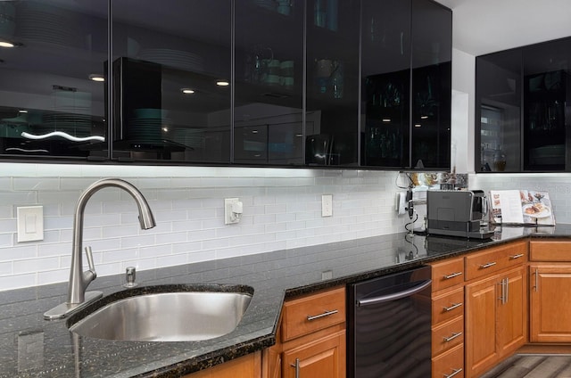 kitchen with hardwood / wood-style flooring, decorative backsplash, dark stone countertops, and sink