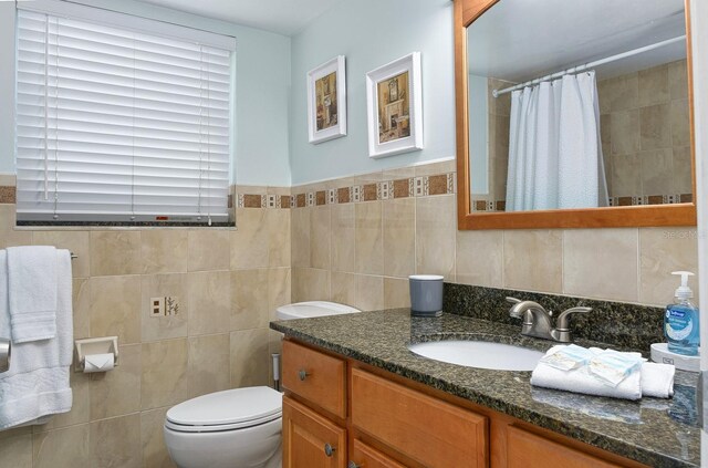 bathroom featuring a shower with curtain, vanity, tile walls, and toilet