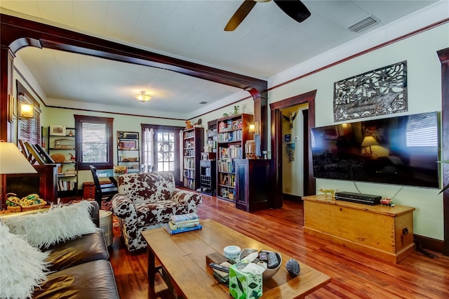 living room with ornate columns, ceiling fan, wood-type flooring, and ornamental molding