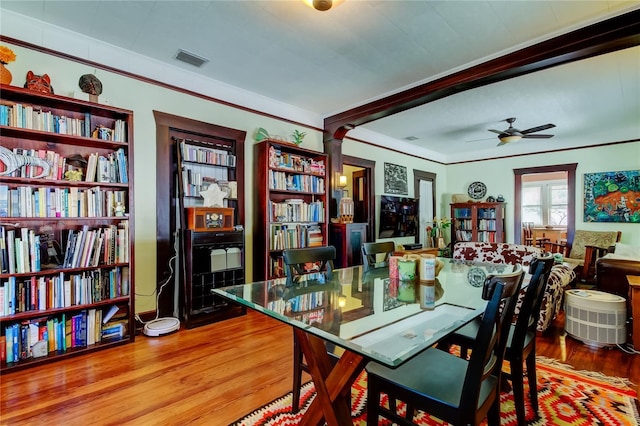 dining room featuring hardwood / wood-style flooring, ceiling fan, and decorative columns