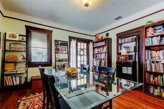 dining room with wood-type flooring and a healthy amount of sunlight